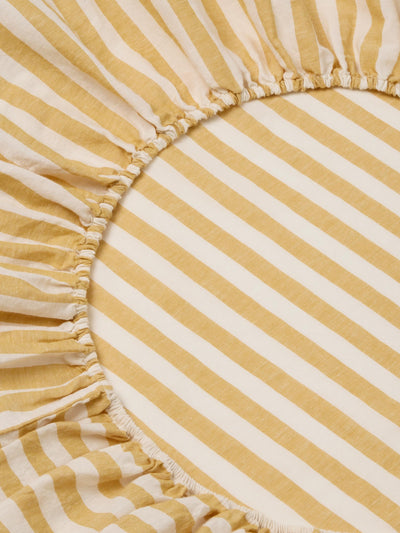 Close-up of a yellow and white striped fitted sheet.