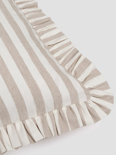 A close-up of a striped textile with alternating beige and off-white vertical stripes and ruffled trim along one corner, shown on a light gray background.