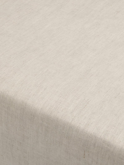 A close-up of a light beige linen fabric texture with a soft shadow across the lower left corner.