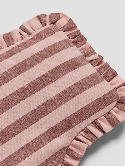 A close-up of a striped textile product, likely a pillow or cushion cover, featuring alternating dusty pink and muted mauve-brown horizontal stripes with a ruffled edge, set against a light gray background.
