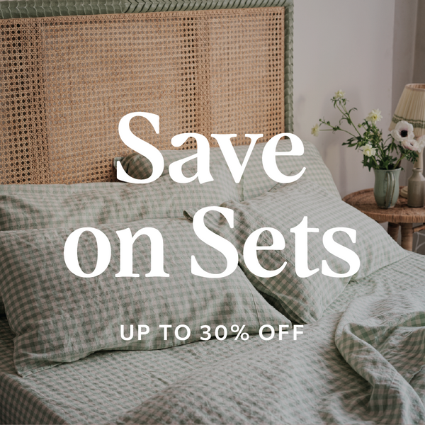 Bed with checkered bedding and text overlay 'Save on Sets Up to 30% Off' in a bedroom setting.